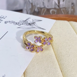 Detailed macro view of purple enamel flower petals with diamond-set stamens on gold ring