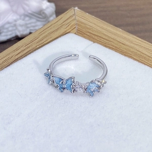 Macro di un anello regolabile in argento con farfalle blu e zirconi scintillanti