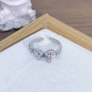 Dettaglio anello a farfalla in argento con smalto blu e cristallo di zircone verde