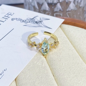 Detail of vintage gold flower enamel ring with marquise cut light blue gemstone