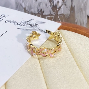 Detail of vintage flower ring featuring pink enamel leaves and small white pearls