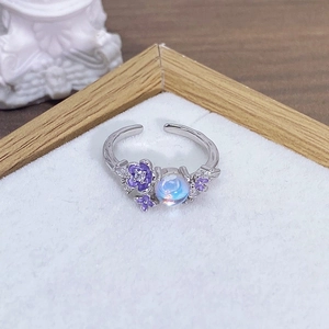 Dettaglio dell'anello regolabile in argento con fiori di smalto viola e pietra di luna
