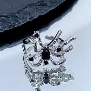 Gros plan d'une bague araignée gothique argentée avec pierres noires et anneau ajustable