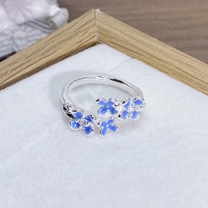 Dettaglio dell'anello con fiori in smalto blu e zirconi su fascia in argento
