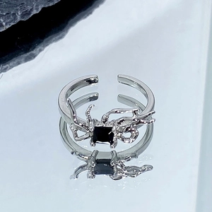 Détail macro de la bague araignée argentée avec pierre noire et anneau réglable ouvert