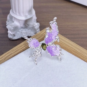 Dettaglio macro dell'anello a farfalla smaltato con ali viola e zircone verde
