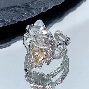 Vue macro d'une bague gothique argentée avec un zircon en forme de cœur champagne