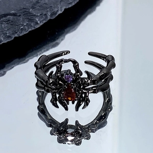 Vue détaillée d'une bague araignée noire gothique avec des gemmes rouges et violettes