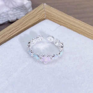 Dettaglio macro di anello in argento regolabile con fiori in smalto e fascia a sfere