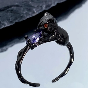 Détail macro de la bague chat noir gothique avec pierre violette sur pierre sombre