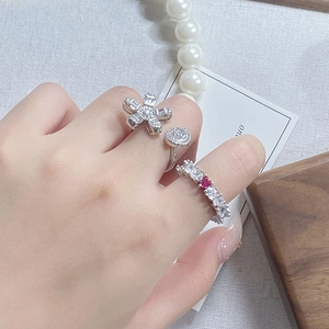 Detail von Vintage-Kamellienring und Zirkonia-Band mit rotem Herzstein beim Tragen