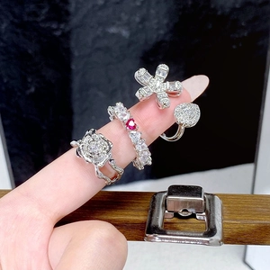 Detailansicht des Vintage-Kamelienrings und Zirkon-Bandsatzes an Modellfingern