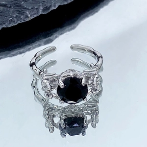 Vue détaillée d'une bague gothique avec pierre noire ronde et texture branche argentée