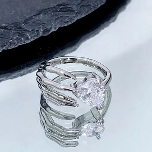 Vue macro d'une bague gothique en forme de main d'os tenant un grand cristal en cœur