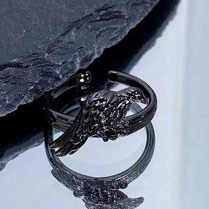 Gros plan d'une bague corbeau gothique noire avec détails de plumes et anneau réglable