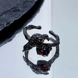 Détail d'une bague gothique corbeau noir avec gemme rouge et anneau en forme de branche
