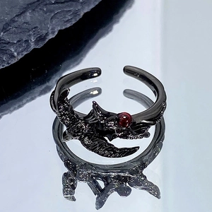 Vue détaillée d'une bague corbeau noire punk avec des ailes et une pierre rouge