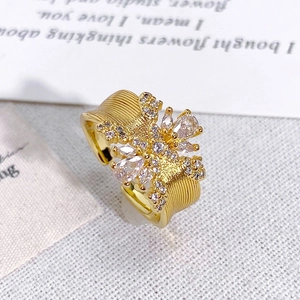 Gros plan d'une bague dorée vintage avec texture brossée et cristaux étincelants