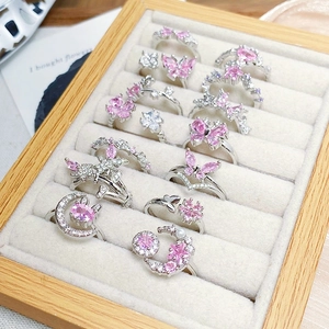 Detailed display of dainty silver rings with pink zircon, butterfly and star designs