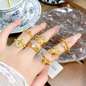 Nahaufnahme von Vintage Goldringen mit Zirkonia, Schmetterling und Fleur-de-lis Motiven