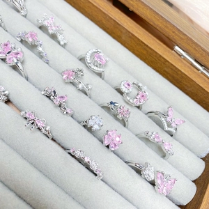 Close-up of assorted butterfly and star rings with pink zircon in a display tray