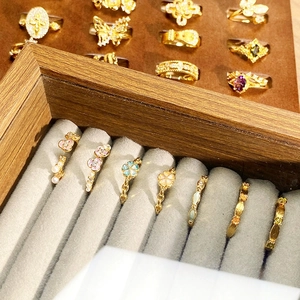Nahaufnahme von Vintage Goldringen mit Emaille und Zirkonia in einer Samt-Schmuckschatulle