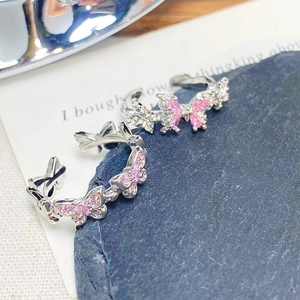 Macro detail of silver butterfly ring with pink zircon and clear stones on stone pad