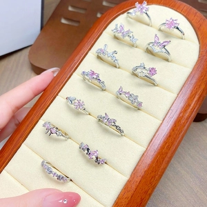 Close-up of delicate silver butterfly rings with pink zircon in a jewelry box