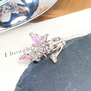 Detail of silver butterfly ring featuring pink marquise-cut zircons and flower accents