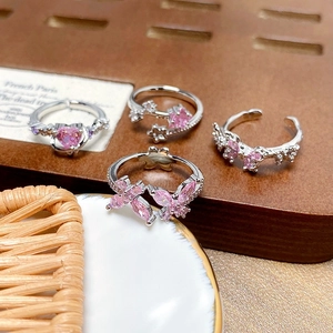 Detail view of four-piece pink zircon butterfly and heart shaped adjustable rings set