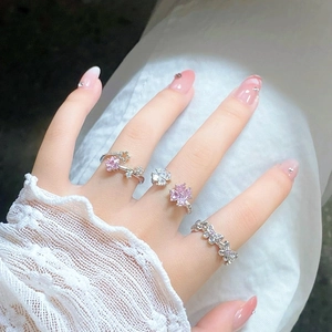 Detail of three layered silver rings with pink star, flower, and butterfly zircon crystals