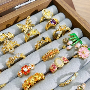 Vintage-Goldringe mit Emaille und Zirkon-Steinen in einer Samtschmuckschatulle