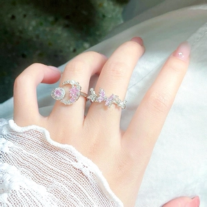 Close-up of silver rings set with pink zircon stars, moon, and butterfly motifs