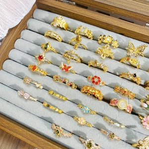 Vintage goldene Ringe mit farbiger Emaille und Zirkonia in einer Holzschachtel