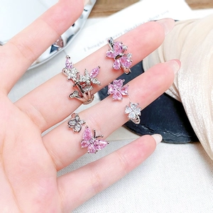 Delicate silver rings with pink zircon butterflies and stars on a hand model