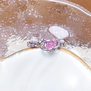 Macro detail of silver ring featuring a pink heart zircon and sparkling star moon accents