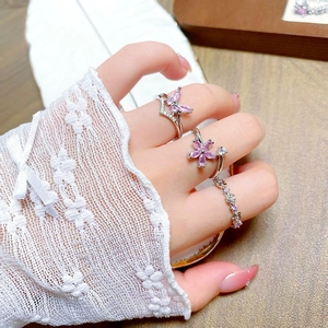 Detailed view of silver butterfly ring set with pink zircon and floral accents