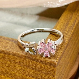Close-up of adjustable silver ring with pink zircon flower and small butterfly detail