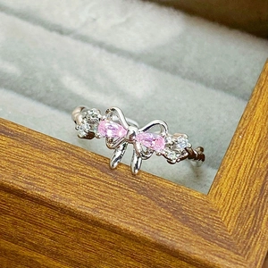Macro shot of silver bow ring with pink pear-shaped stones and white zircon details