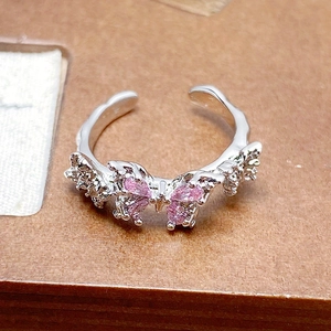 Close-up of silver butterfly ring with pink zircon stones and textured open band