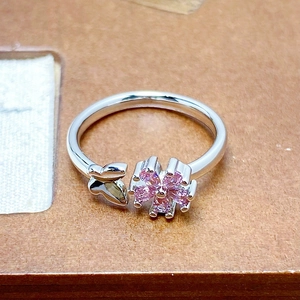 Macro shot of silver ring featuring pink cubic zirconia flower and butterfly details