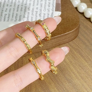 Gros plan de bagues vintage dorées avec zircon rose et détails de design en bambou