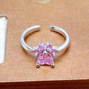 Macro detail of silver cat paw ring with pink zircon heart and adjustable band