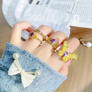 Ensemble de bagues dorées vintage avec zircon violet et motif papillon sur main de mannequin