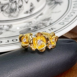 Detail eines Vintage-Goldblumenrings mit gebürsteten Blütenblättern und Zirkonia