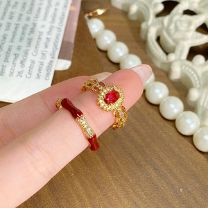 Gros plan sur bague vintage dorée avec pierre ovale rouge et détails en zircon