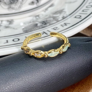 Makro-Detail des Vintage-Goldrings mit grünen Steinen und funkelnden weißen Zirkonia