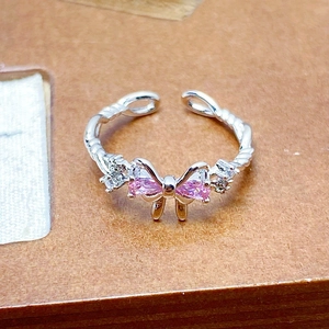 Detailed close-up of adjustable silver twist ring with pink zircon butterfly element