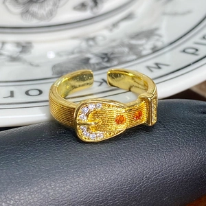 Nahaufnahme des Vintage-Gürtelschnallenrings in Gold mit Zirkonia auf Keramikteller