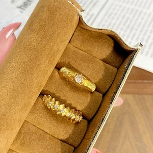Détails de bagues vintage dorées avec zircons dans un coffret en velours marron